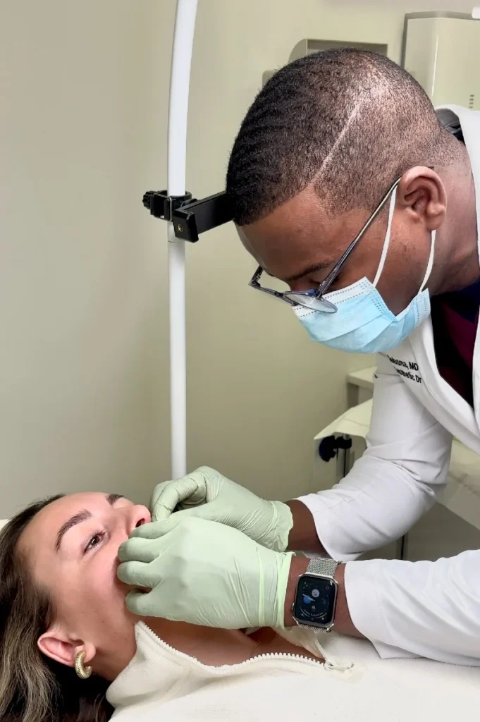 Dr Peguy Télusma en consultation avec une patiente, evaluation du visage avant traitement, clinique GLIF Medical Montreal
